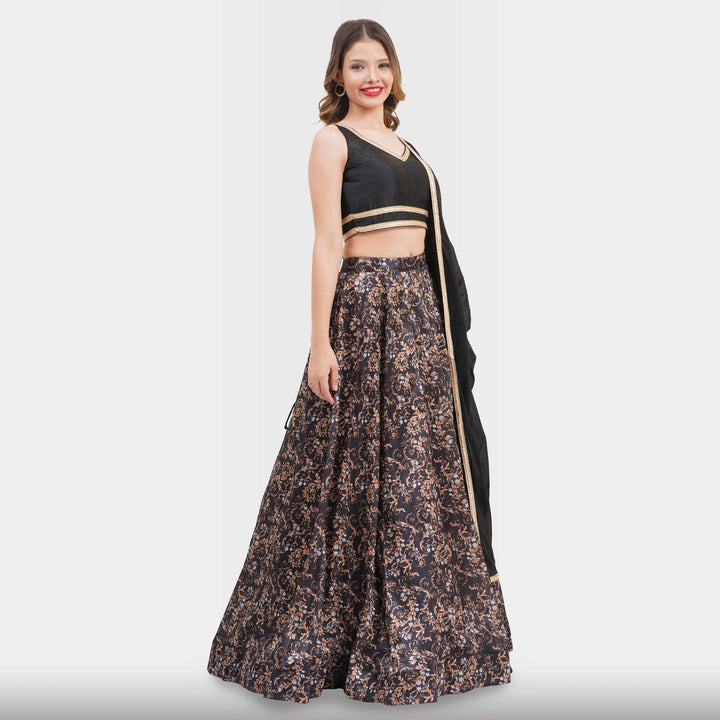 Woman wearing a black top and floral skirt with a black dupatta on a white background