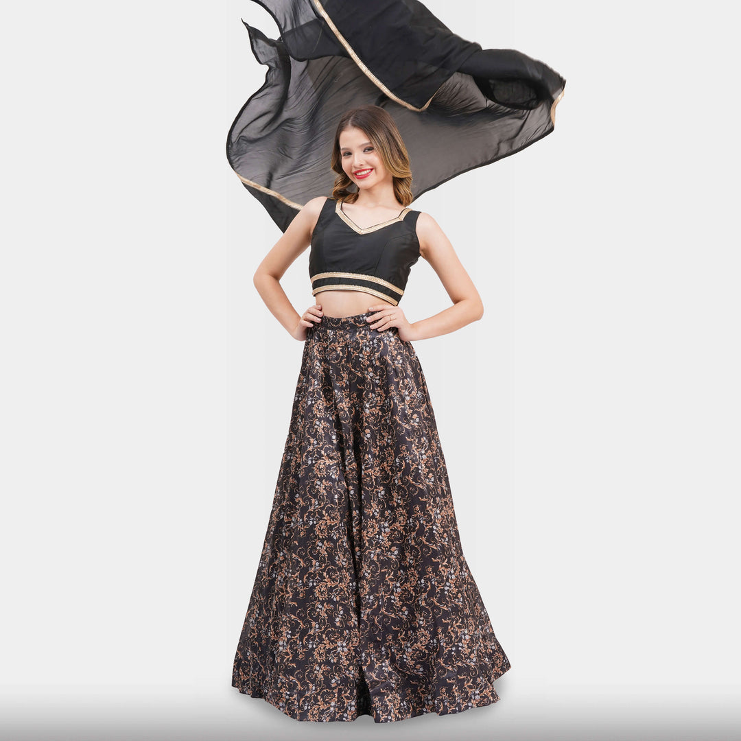Woman wearing a black and gold traditional outfit with a flowing black fabric on a white background